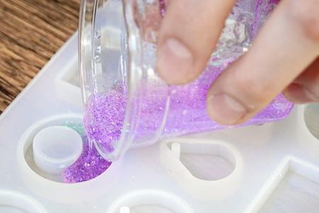 Pouring purple glitter resin into a resin mold