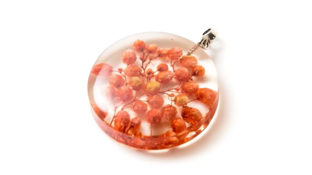 small dried pink flowers in a resin pendant